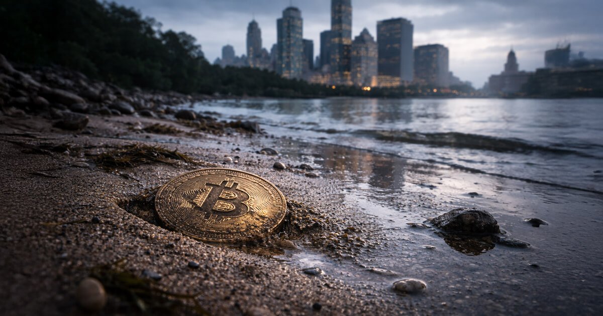 Bitcoin coin resting on a quiet shoreline with a city skyline in the background, reflecting market uncertainty as traders track Nvidia, the Fed, and BofA’s 7,100 target amid fears of a sharp de-rating